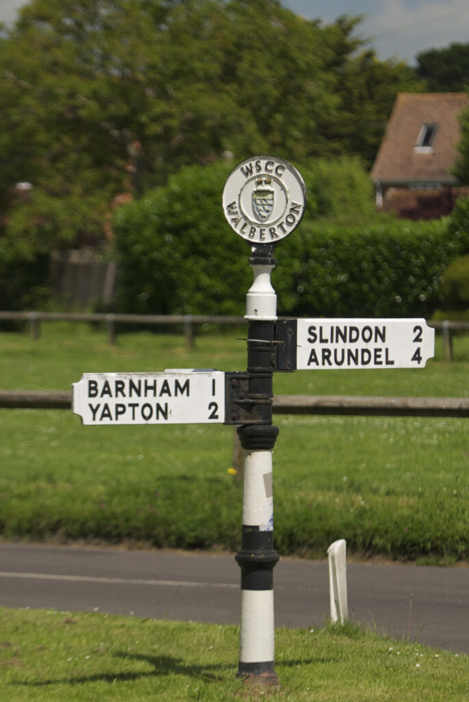 Black and White Fingerpost signs showing direction to Barnham/Yapton and Slindon/Arundel